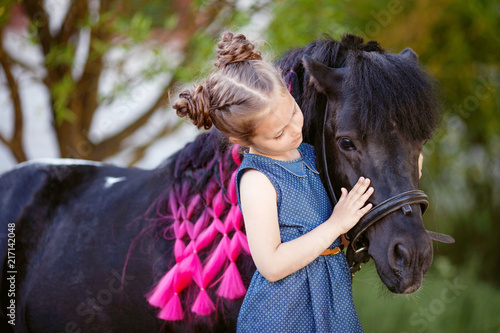 Cute little girl and pony in a beautiful park © fadzeyeva