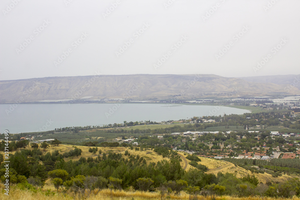 The calm waters of the Sea of Galilee from the hills near the Town of Tiberias in early evening on a hazy day in May 2018 