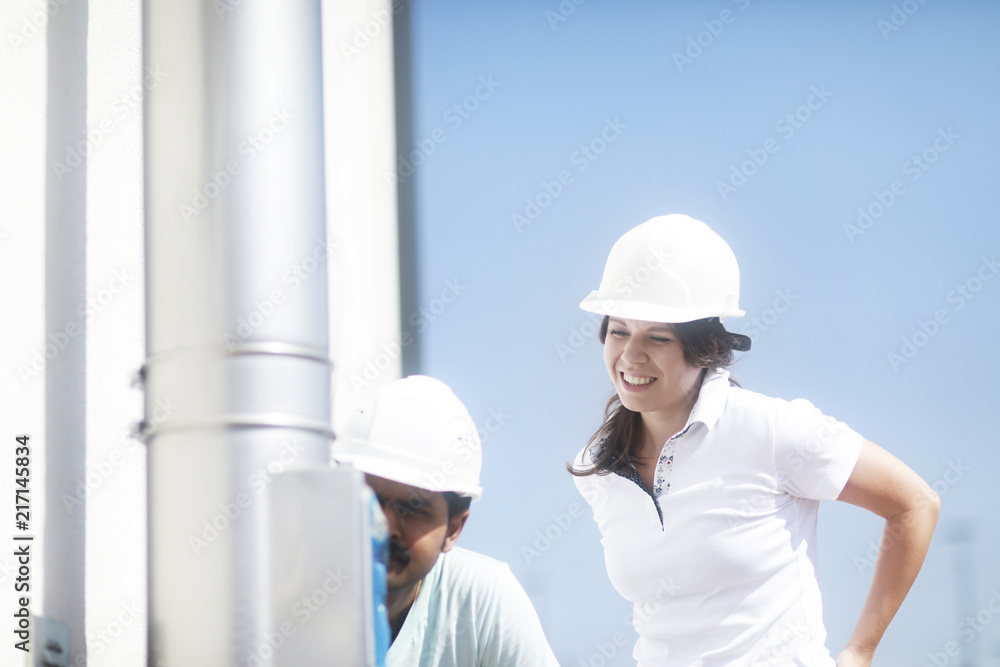 Techniker mit Helm Paar überprüft Anlage aussen Techniker mit Helm Paar überprüft Anlage aussen