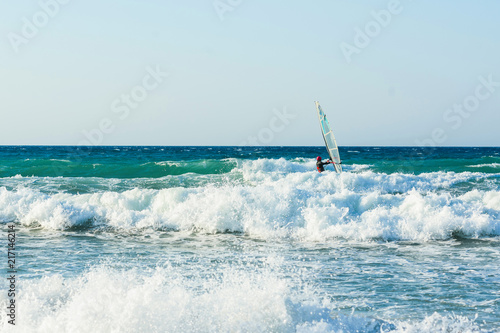 Windsurfers in the sea on Crete on sunset. Windsurfing in Heraklion