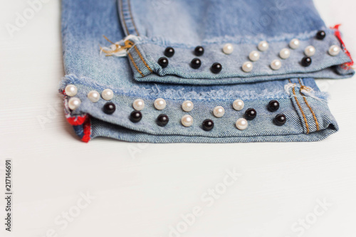 The design of jeans. Beads in the form of pearls are sewn to the jeans. Fashionable jeans.