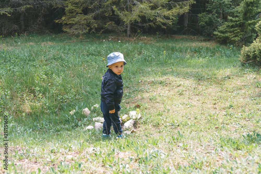 Boy on Meadow with Stones