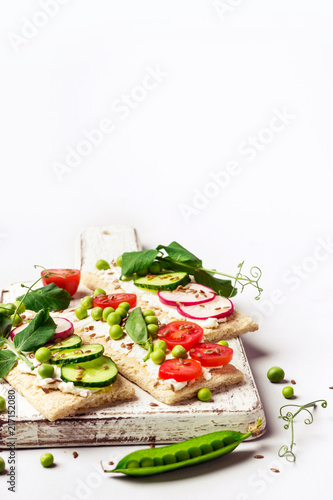 Healthy sandwiches with soft cheese and raw vegetables on crisp bread