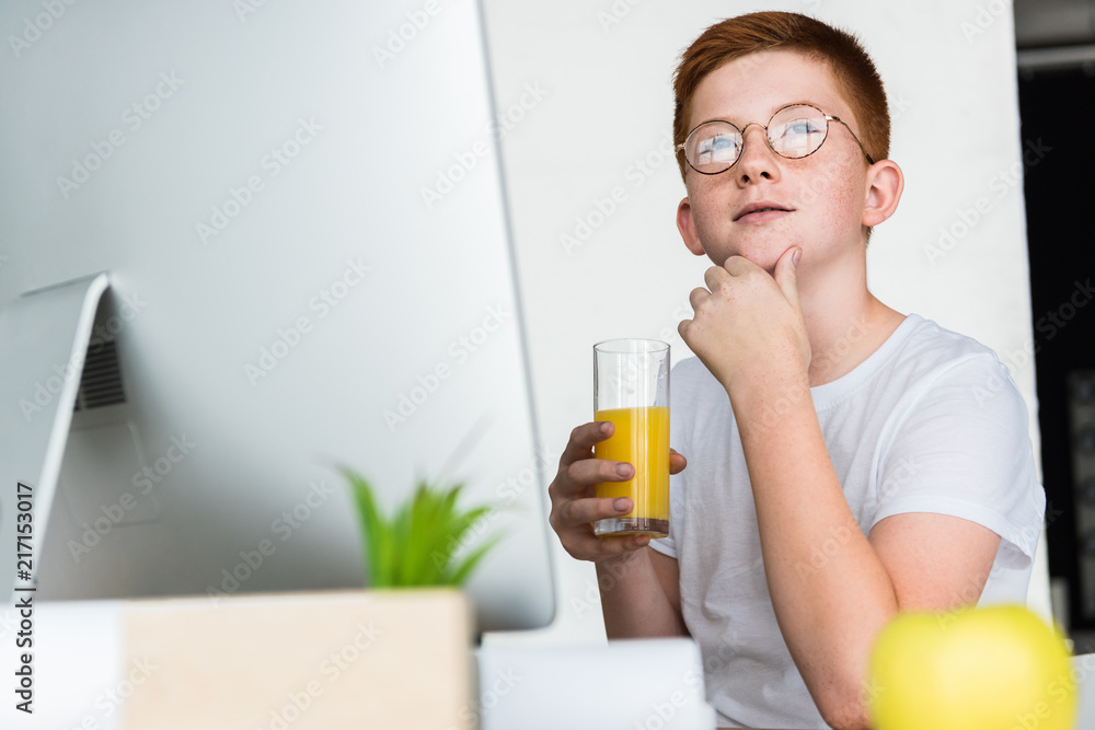 pensive preteen ginger hair boy holding glass of juice at home pensive preteen ginger hair boy holding glass of juice at home