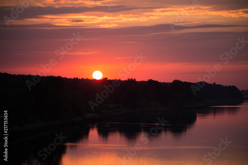 Fototapeta Naklejka Na Ścianę i Meble -  Bright, colorful evening landscape over the river Daugava of pink and purple tones. Dramatic sunset scenery in Latvia, Northern Europe.