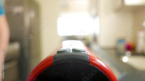 man put a capsule in an espresso coffee maker machine and press the start button