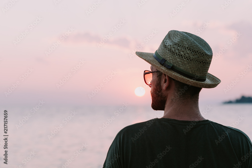 Young man enjoying sunset by the sea