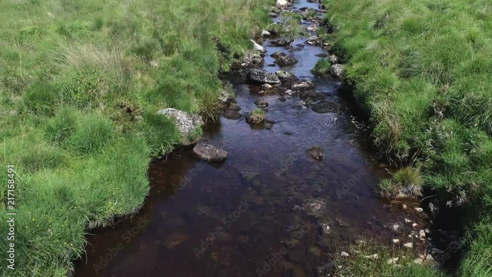 Very low angled birdseye aerial tracking forward along a rough rocky creek river. Dartmoor, Devon, England Very low angled birdseye aerial tracking forward along a rough rocky creek river. Dartmoor, Devon, England