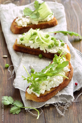 Crostini with cream cheese, green vegetables and herbs, vertical