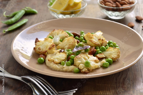 Salad with roasted cauliflower and green peas, almonds served on vegetable puree