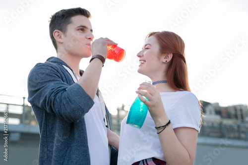 Wonderful taste. Joyful nice man enjoying his drink while standing together with his girlfriend