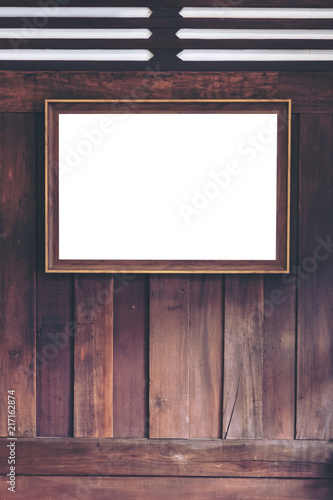 Mockup image of an antique golden picture frame with blank white screen on wooden wall background