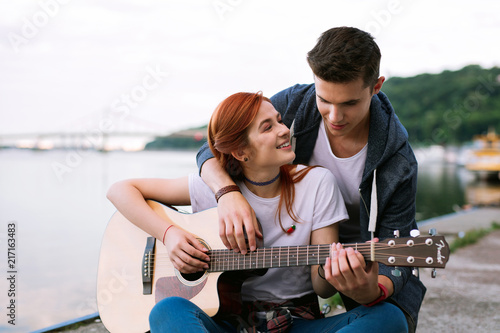 My hobby. Nice happy woman playing the guitar while being together with her boyfriend © Viacheslav Yakobchuk