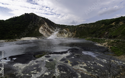 Black ground of lake of hot spring water with smoke