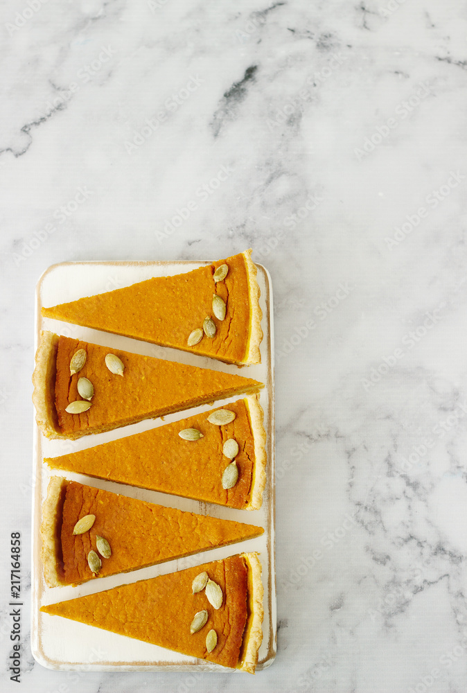 Traditional American pumpkin pie for Thanksgiving Day or Halloween on a light background. Rustic style.