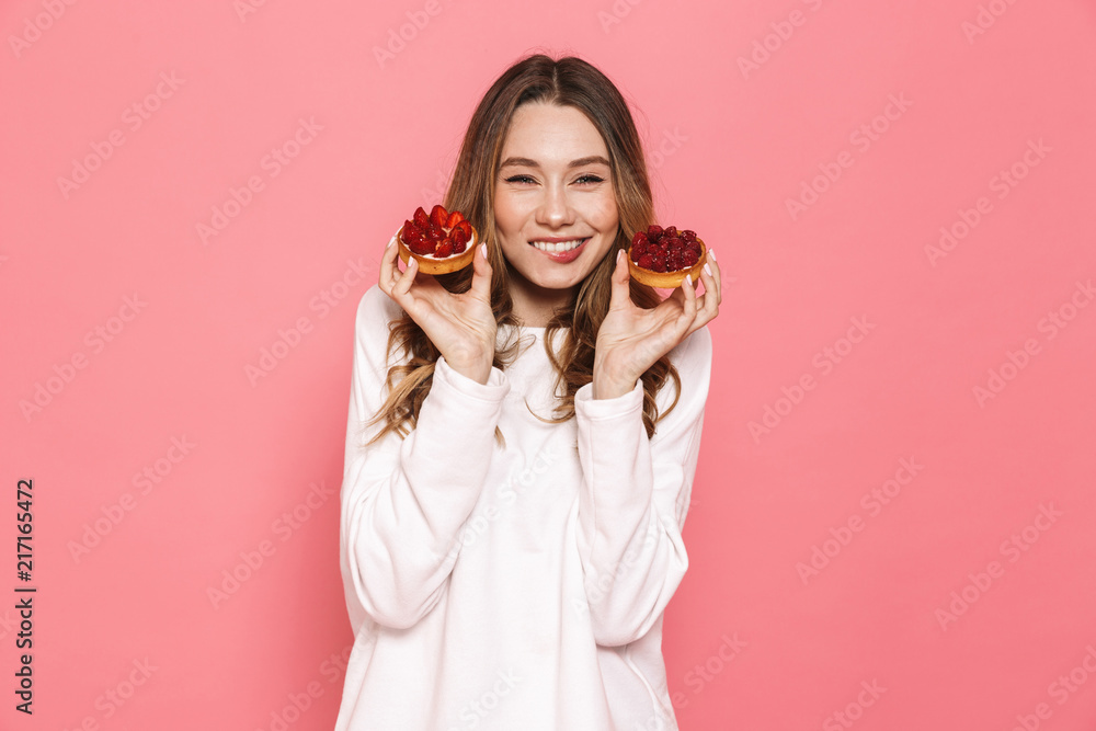 Portrait of a delighted young woman showing pastry Portrait of a delighted young woman showing pastry