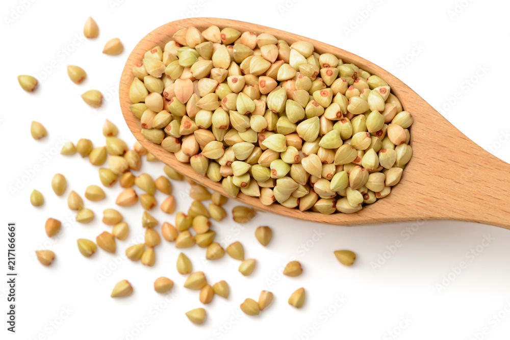 uncooked buckwheat in the wooden spoon, isolated on the white background, top view uncooked buckwheat in the wooden spoon, isolated on the white background, top view