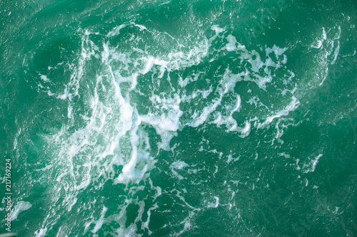 surface of turquoise ocean water with white foam, background, texture