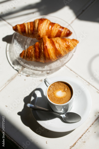 Obraz na płótnie Hot coffee and croissant breakfast in a sunny morning, natural light. w salonie