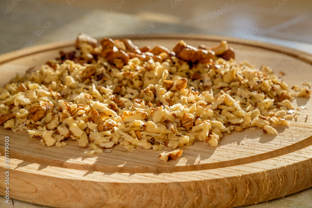 On a cutting board finely chopped walnuts for eat cooking. Closeup view. On a cutting board finely chopped walnuts for eat cooking. Closeup view.
