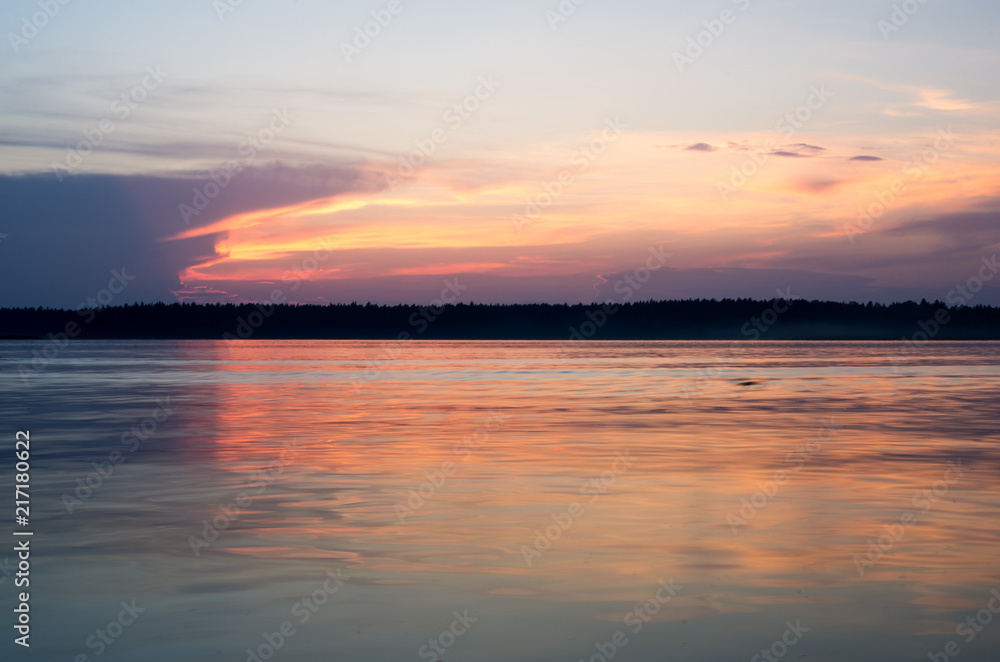 Sunset on the lake. Beautiful sunset nature. Evening landscape. Clouds over the lake. The horizon at sunset. Sea, lake at sunset.
