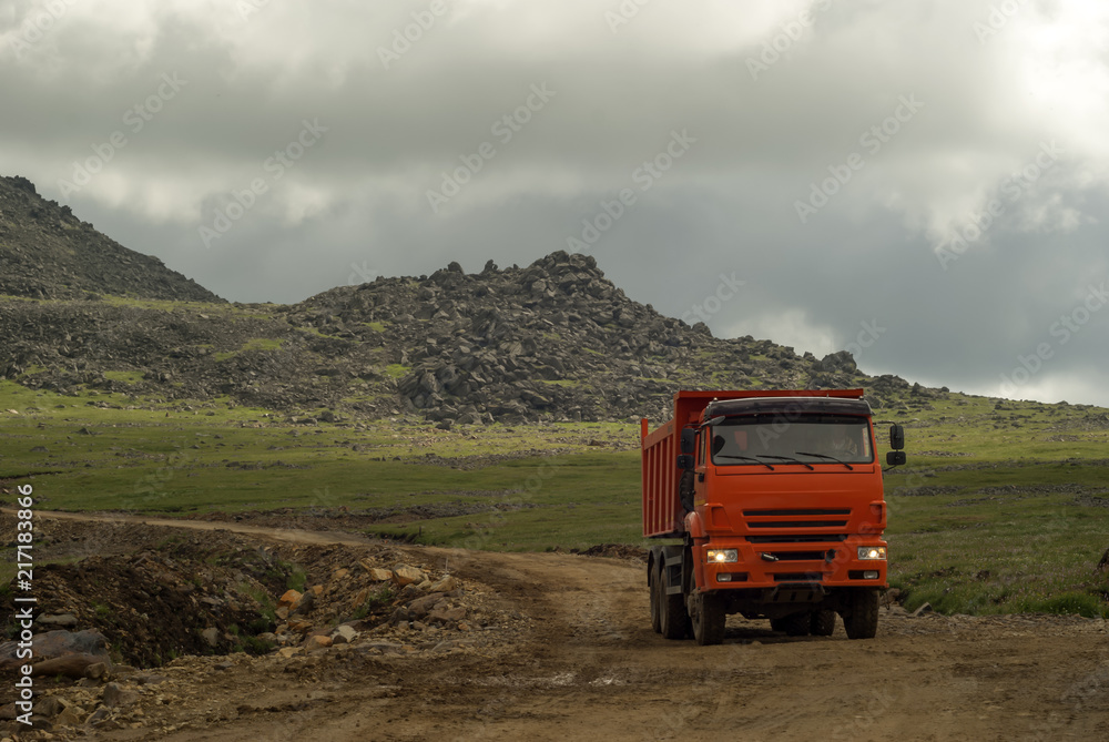 dump truck rides on the mountain road under construction dump truck rides on the mountain road under construction
