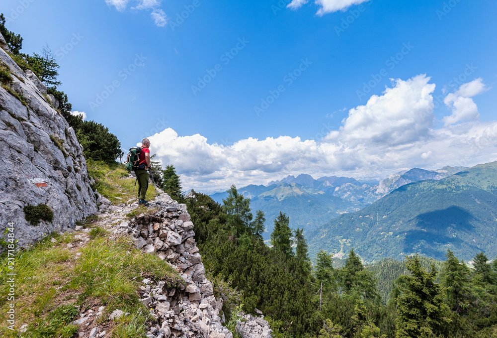 Hiker walks on a mountain trail with wonderful view to admire.