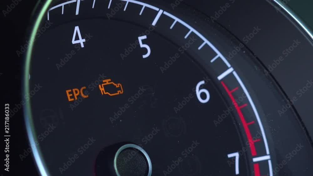Closeup on a car tachometer with icon of engine Closeup on a car tachometer with icon of engine
