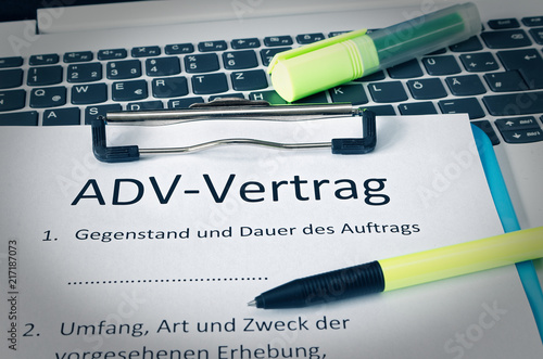 klemmbrett mit einem Vertrag und Aufschrift in deutsch ADV-Vertrag in english ADV-Vertrag und Gegenstand und Dauer des Auftrags und Umfang Art und Zweck der vorgesehenen Erhebung photo