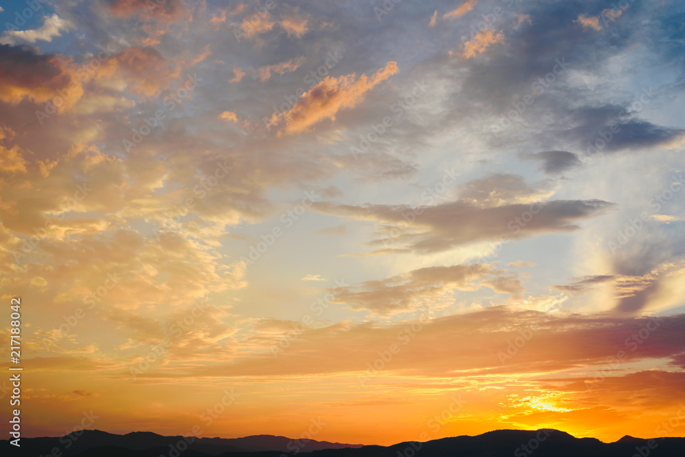 Fototapeta premium Beautiful sunset with the sun of orange tones behind the mountains and deep blue sky