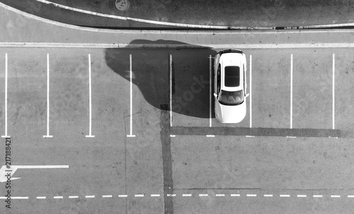 Empty parking lots, top view. Aerial view of a car parked alone in a parking, free lots. Black and white photo