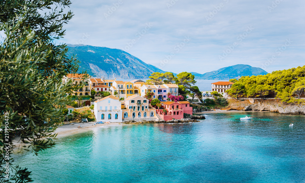 Panoramic view of Assos village in Kefalonia, Greece. Turquoise blue colored water in Mediterranean sea and beautiful cute colorful local houses