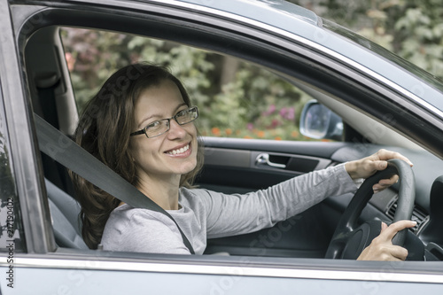 Happy young woman driver sits in car.  © Oleksandr