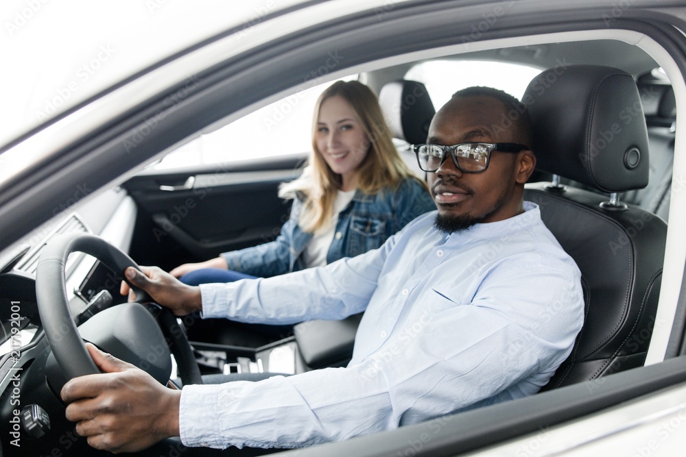 Racial family choosing a new car in the showroom sitting in the car Racial family choosing a new car in the showroom sitting in the car