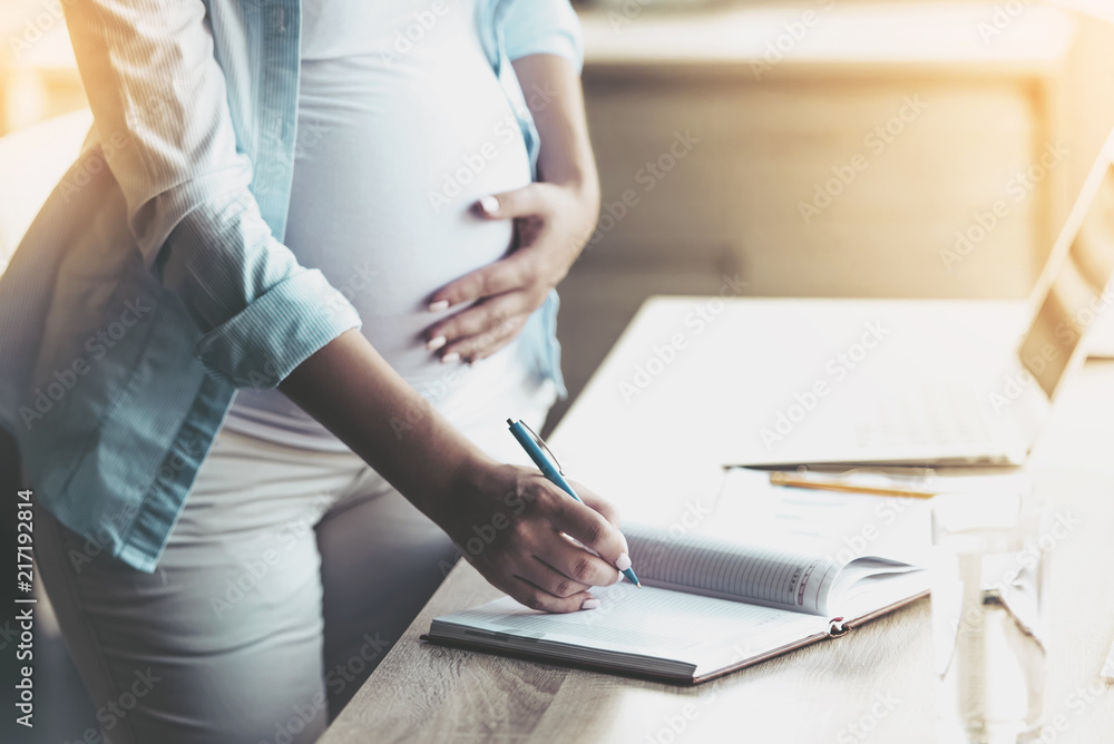 Beautiful Pregnant Woman Writing in Notebook.
