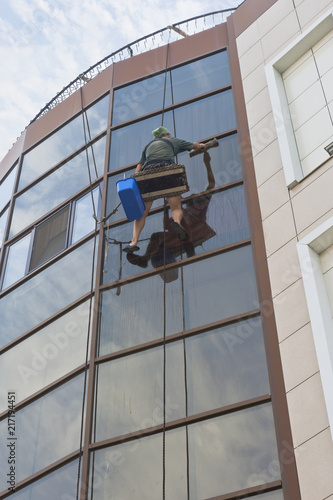 Industrial climber washes windows of an office building