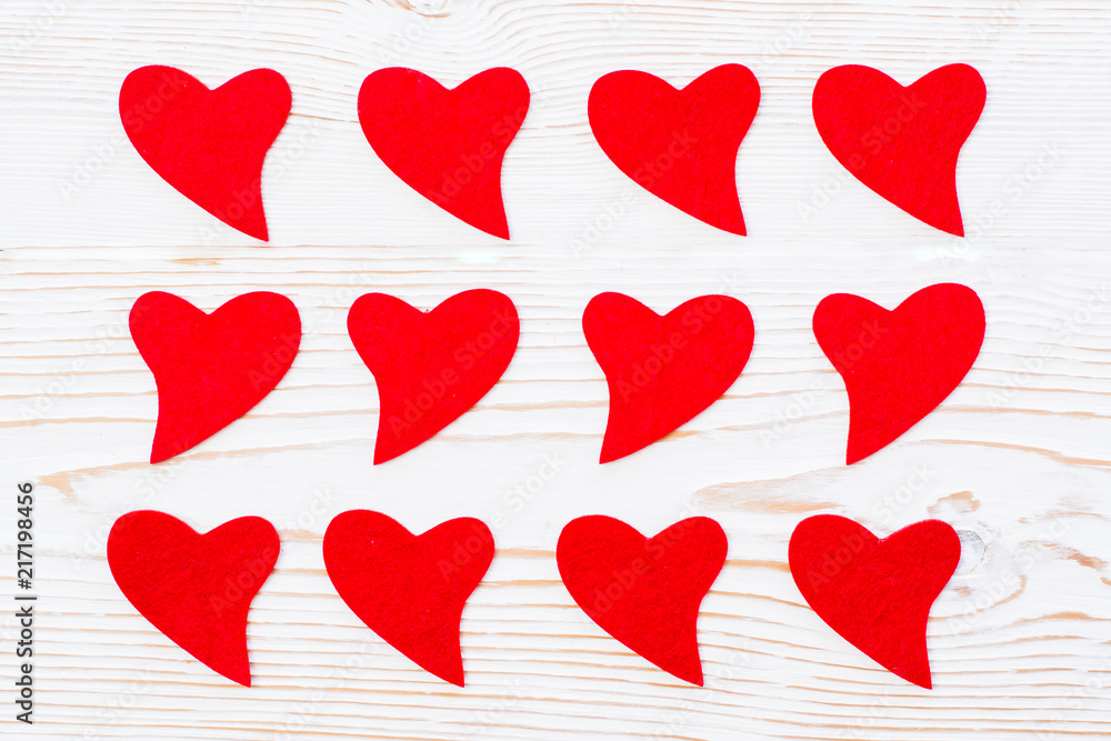 Red hearts of felt on a white wooden background