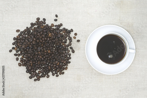 Good morning! Coffee beans and coffee mug. Light background
