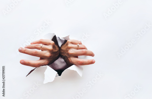 Canvas Print Female hands tear open a hole in white paper
