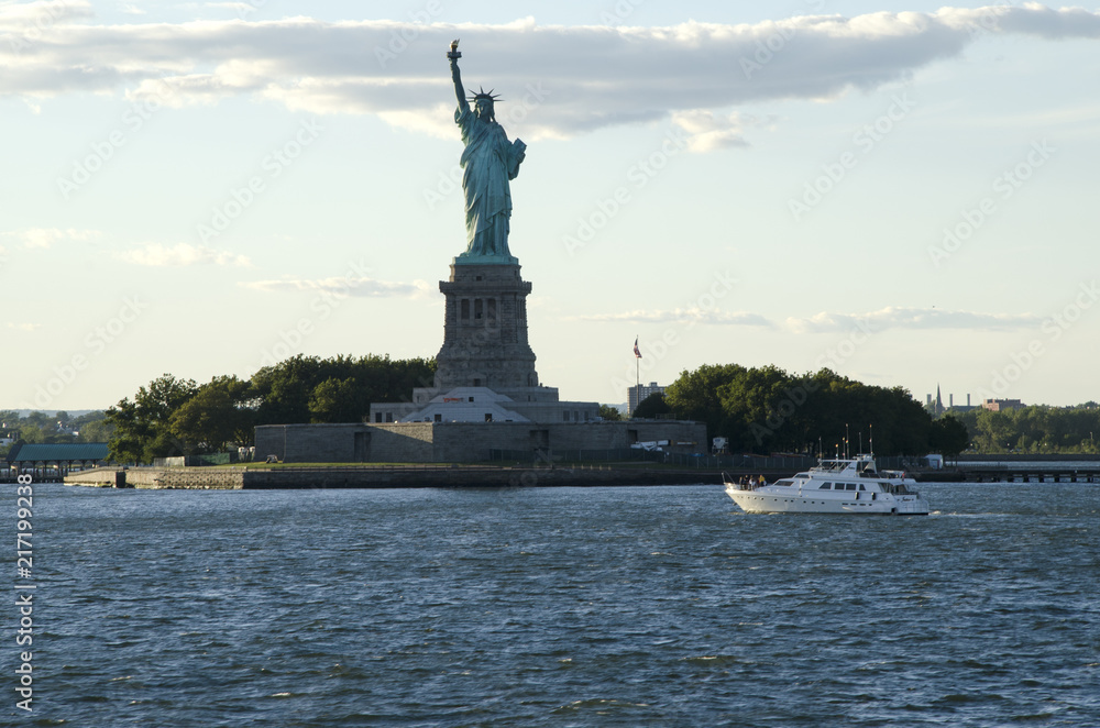 Statue of Liberty and a boat crossing the bay, New York