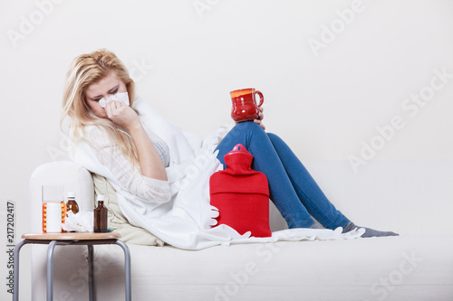 Woman being sick having flu lying on sofa