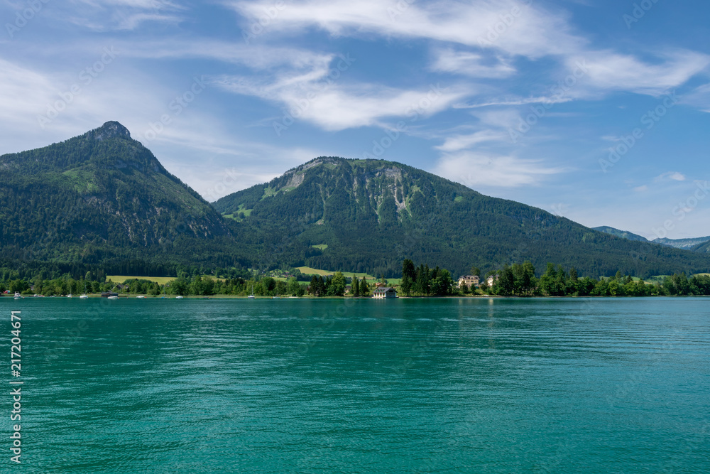 Lake called Wolfgangsee in Austria with Mountains in the Background and Clouds on the Sky