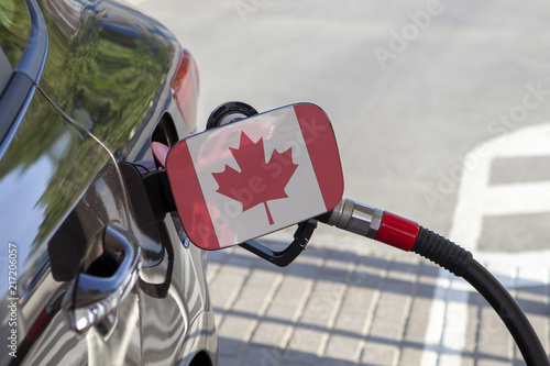 Fueling car with petrol pump at a gas station.