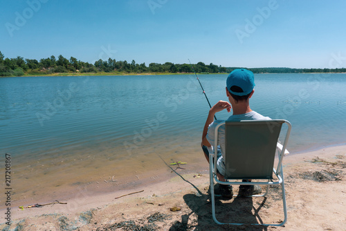 boy teenager is fishing on the fishing rod in summer.