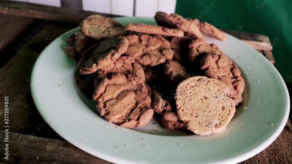 very slow pan right of a blue plate containing a pile of homemade chocolate cookies biscuits very slow pan right of a blue plate containing a pile of homemade chocolate cookies biscuits