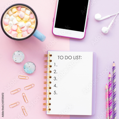 Top view flat lay picture with notepad as mockup for your design and different accessories on pink background. To do list. photo