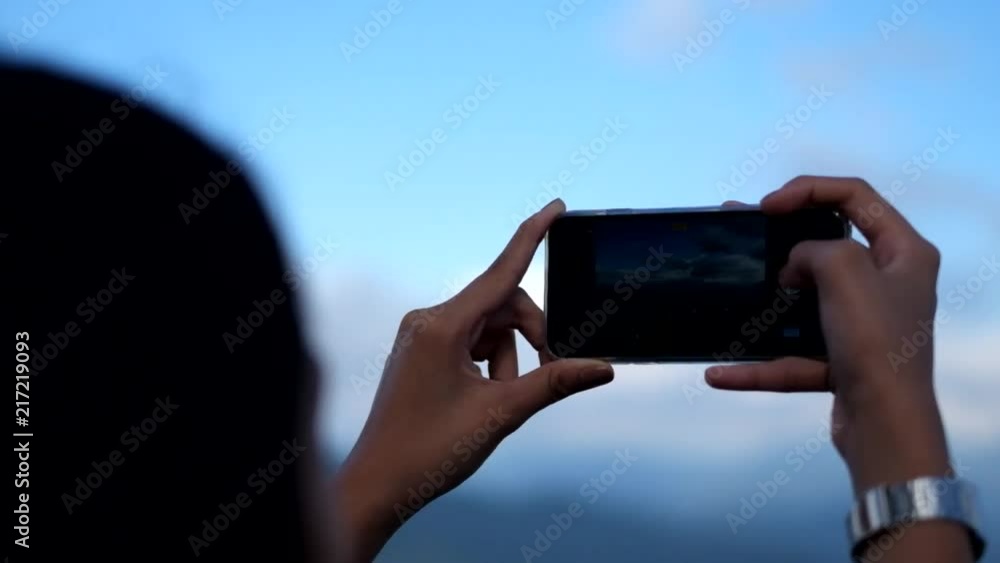 A female tourist taking pictures of the beautiful scenery from the top of a mountain in Mines View Park in Baguio, Philippines. A female tourist taking pictures of the beautiful scenery from the top of a mountain in Mines View Park in Baguio, Philippines.