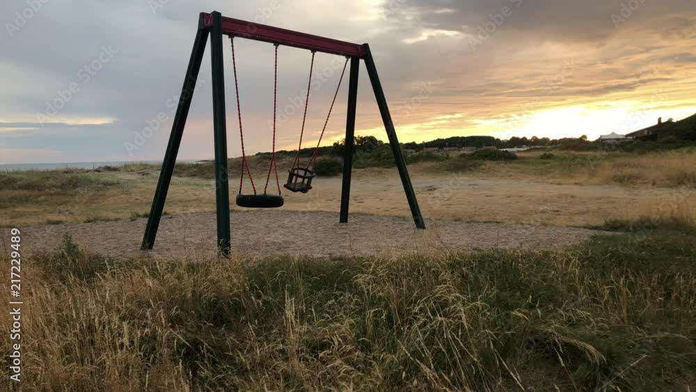 Still shot of an empty swing in the sunset. Normal Perspective. Still shot of an empty swing in the sunset. Normal Perspective.