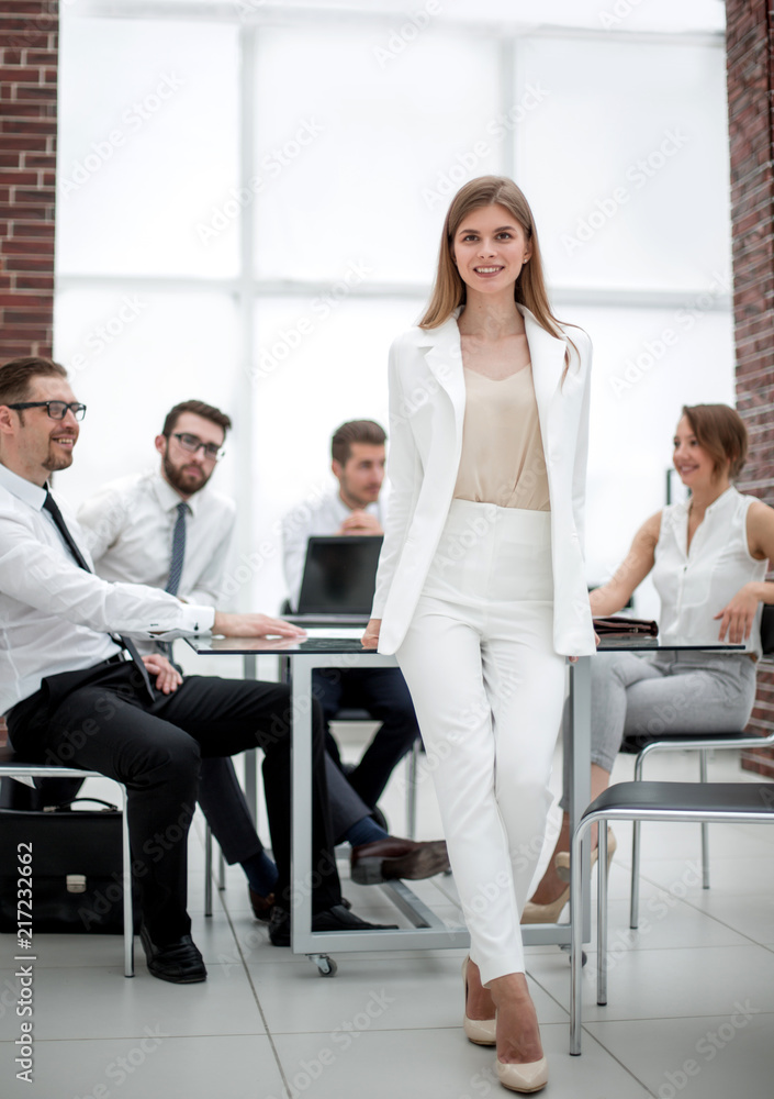 Obraz premium young business woman standing near desktop