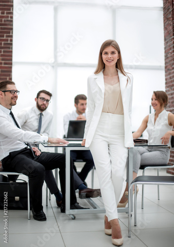 young business woman standing near desktop